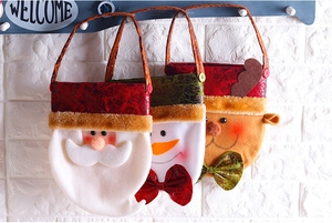 Close-up of Santa and reindeer felt gift bags with plush trim and metallic handles