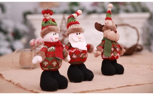 Detail of Christmas standing dolls including Santa, snowman and reindeer on a rustic surface