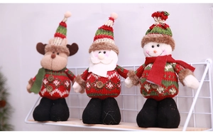 Close-up of three festive knitted Christmas plush dolls including Santa, snowman and elk