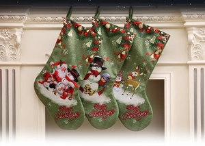 Detailed view of three green burlap Christmas stockings with festive prints on a white fireplace