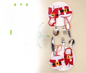 Detailed view of Christmas cutlery holders shaped like Santa Claus outfits on a white plate