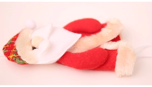 Dettaglio macro di un addobbo di Babbo Natale in feltro rosso e bordo in morbido peluche