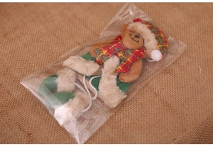 Dettaglio di orsetto natalizio in peluche con sciarpa e cappello in confezione