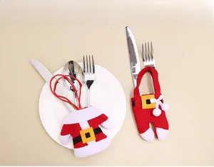 Detail shot of mini Santa outfit cutlery holders on a plate for Christmas table setting