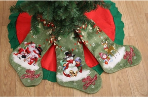 Close-up of three vintage green linen Christmas stockings with festive cartoon prints
