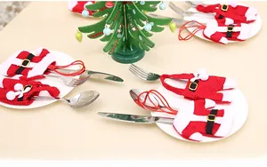 Festive Christmas table cutlery holders in Santa clothes and pants style with wooden tree