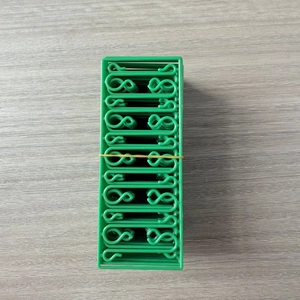 Close-up of green plastic Christmas tree ornament hooks bundled with a yellow band