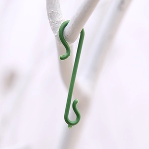 Green S-shaped plastic hooks for Christmas tree ornaments and festive decorations