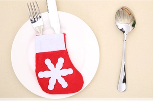 Mini Christmas stocking cutlery holder with snowflake detail placed on a white ceramic plate