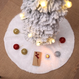 White plush Christmas tree skirt made of faux fur on rustic background with festive ornaments