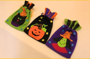 Three Halloween drawstring gift bags featuring black cat, pumpkin, and witch patterns