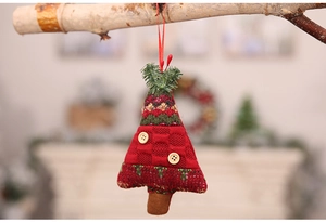 Detail of red knit Christmas tree ornament with wooden buttons on wooden branch