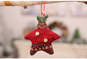 Detail of red knitted Christmas star ornament with wood buttons hanging on a branch