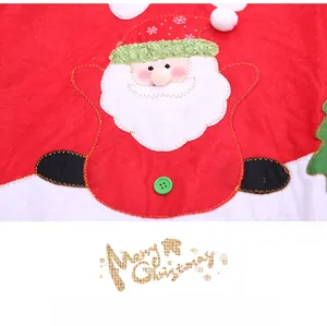 Detail of red Christmas tree skirt featuring a felt Santa Claus and Merry Christmas text