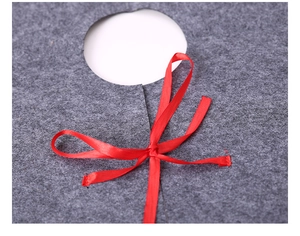 Close-up of grey felt Christmas tree skirt with a red ribbon bow tie detail