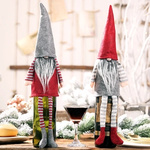 Close-up of Christmas gnome wine bottle covers with red and grey striped knit legs