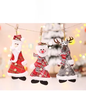 Detail of fabric Christmas dolls with wood clips hanging on a string in a warm setting