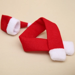Mini Christmas wine bottle decor set with red white scarf and hat on beige background