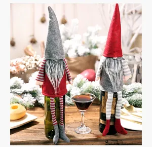 Detail of Christmas gnomes wine bottle covers with long legs and striped hats
