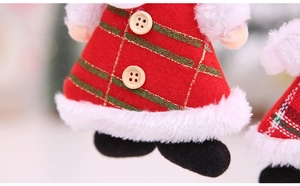 Detail of handmade Christmas elf doll featuring red felt fabric and wooden buttons