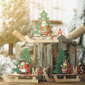 Detail von hölzernen Weihnachtsbaum-Ornamenten mit Nikolaus und Schneemann auf Schlitten