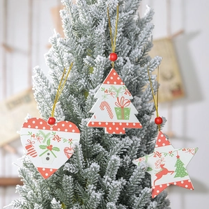Detail of wooden Christmas ornaments featuring heart, star, and tree shapes on a tree