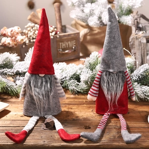 Set of 2 Christmas gnome wine bottle covers in red and grey on a rustic wooden table