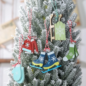 Close-up of hand-painted wooden Christmas ornaments hanging on a snowy festive tree branch