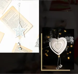 Hollowed wood star and heart Christmas ornaments hanging on a festive holiday tree