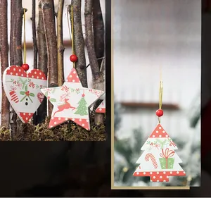 Close-up of wooden Christmas ornaments with reindeer and snowflake patterns hanging on branches