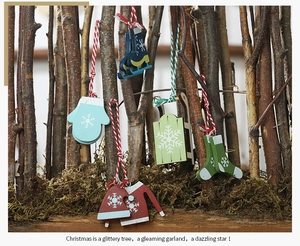 Detail of wooden Christmas ornaments hanging on a rustic branch with colorful winter shapes