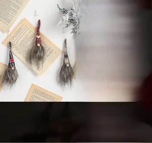Close-up of handmade Christmas gnome pendants with plaid hats hanging on a snowy tree