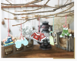 Close-up of 5-piece set of hand-painted wooden Christmas ornaments on branches