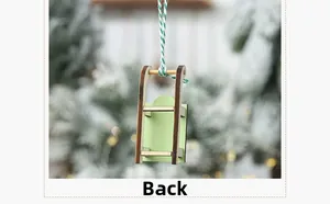Back view of a mini green wooden ski sled Christmas tree ornament with striped hanging cord