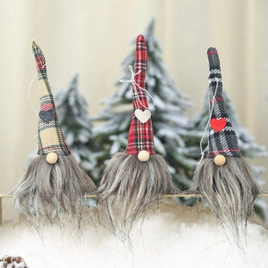 Three Christmas gnomes with plaid hats and heart patches on snowy background