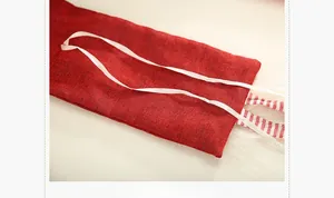 Detail of red burlap gift bag featuring a white silk drawstring and striped lining