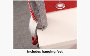 Close-up of Christmas gnome bottle cover with red hanging legs on table edge