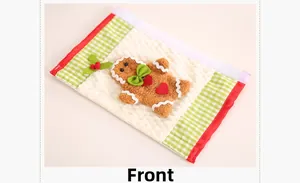 Close-up of Christmas gingerbread man on waffle fabric handle cover with green bow detail