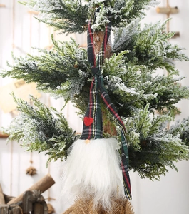 Détail d'un gnome de Noël avec un cœur rouge et un bonnet à carreaux sur un sapin