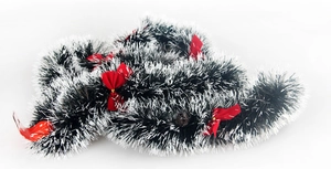 Detail of fluffy dark green and white Christmas tinsel garland with festive red bows