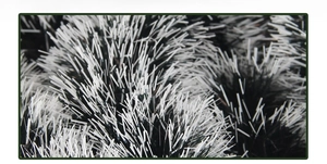 Detail of fluffy dark green and white Christmas tinsel garland with pine needle texture