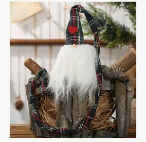 Détail d'un gnome de Noël avec un long chapeau à carreaux et une barbe blanche sur bois