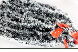 Detail of dark green and white PET tinsel garland with festive red star hanging tags