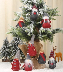 Set of 8 knitted Christmas plush dolls hanging on a snowy tree with warm festive lighting