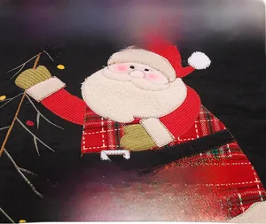Detail of Christmas tree skirt with Santa Claus applique and red plaid fabric texture