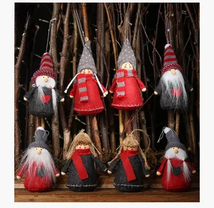 Close-up of handmade Christmas gnome ornaments with red hats and knitted details