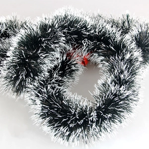 Dark green Christmas tinsel with white snowy tips for festive holiday tree decoration