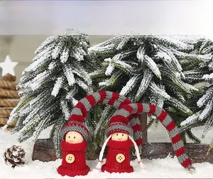 Close-up of two Christmas knit dolls with striped hats and wooden button details