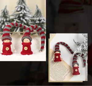 Detail of knitted Christmas doll ornaments with long striped hats and wooden buttons