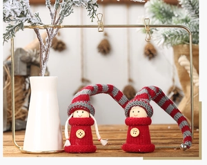 Close-up of two Christmas knit gnomes with wooden heads and long striped elf hats